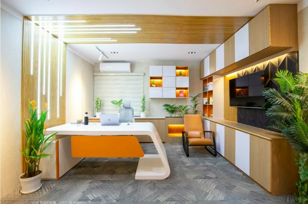 Branded executive office with orange accent storage, integrated lighting and meeting area in Noida
